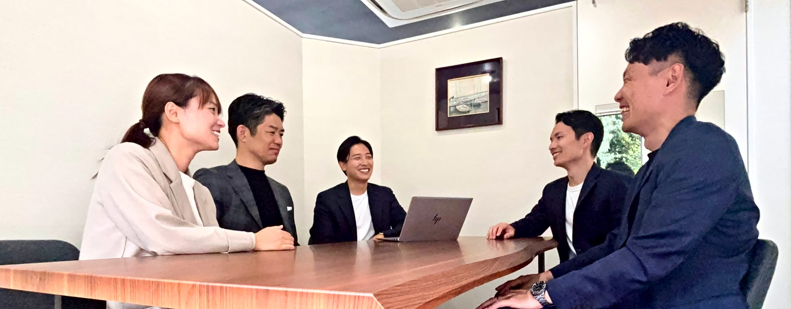 テーブルを囲んで話し合うASCEND ONEのメンバー5人