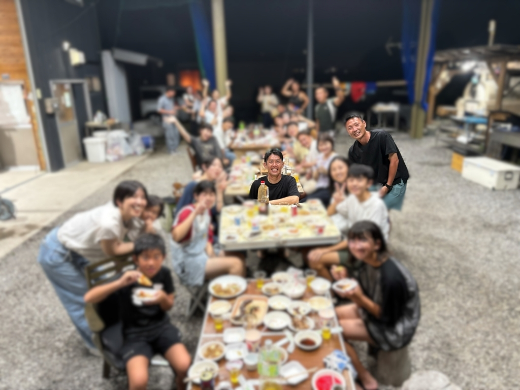 交流イベントで、みんなでテーブルを囲んで食事を楽しむ様子